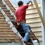 Sider installing siding on the house wall