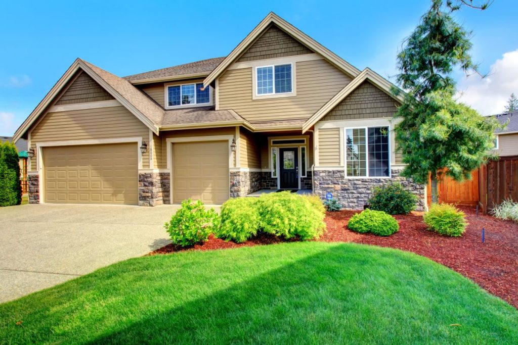 new beige house siding installed and green grass for curb appeal